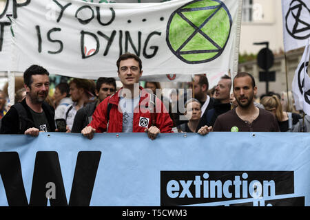 London, Greater London, UK. 23rd Apr, 2019. Extinction Rebellion activists are seen behind a large banner marching to Parliament to deliver letters to their MPs during the Extinction Rebellion march in London.Extinction Rebellion protesters march from Marble Arch to Parliament Square, attempting to deliver letters to their MPs. Extinction Rebellion activists were permitted to be in Parliament Square but not to enter Parliament. After several attempts to deliver the letters, the activists reached an agreement with MPs through the police. Ten activists were allowed to deliver the Stock Photo