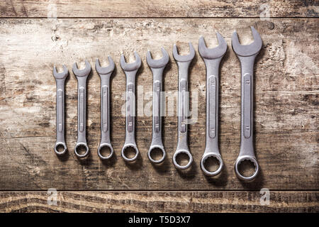 Wrenches of different sizes on wooden background. Top view Stock Photo