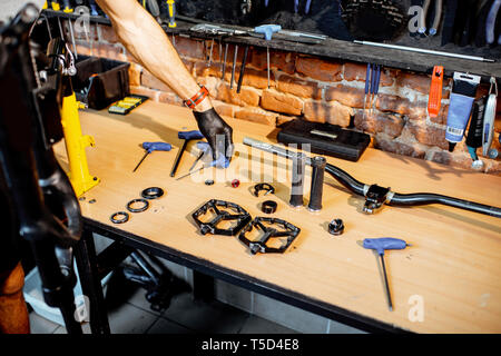 Working place with bicycle parts and working tools on the table of the bicycle workshop Stock Photo