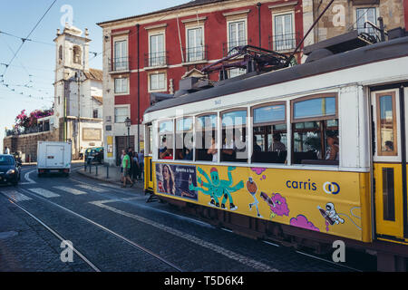 Traditional yellow tram on Largo Portas do Sol square in Lisbon, Portugal Stock Photo