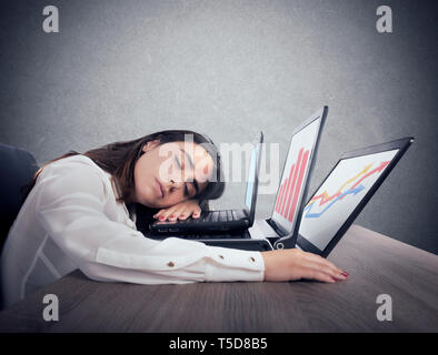 Female worker falls asleep while simultaneously working on three laptops Stock Photo