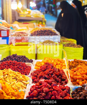 Women in hijab looking at dried fruits and nuts at stall of Grand Bazaar, Tehran, Iran Stock Photo