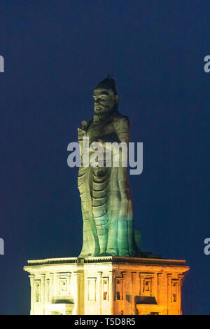 Vertical view of the Thiruvalluvar Statue lit up at night in Kanyakumari, India.