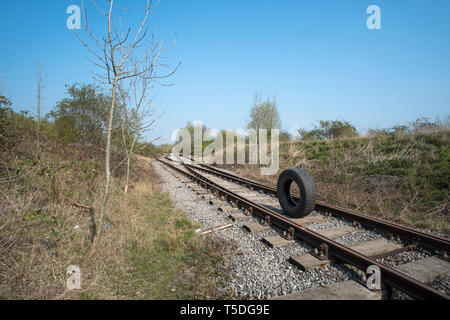 Old rubber lorry tyre in the middle of a railway track Stock Photo