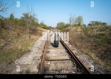 Old rubber lorry tyre in the middle of a railway track Stock Photo