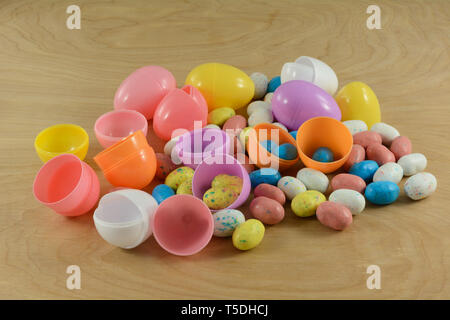 Preparing for Easter egg hunt by putting candy covered malted milk balls in shape of bird eggs into eco-friendly recyclable plastic Easter eggs made f Stock Photo