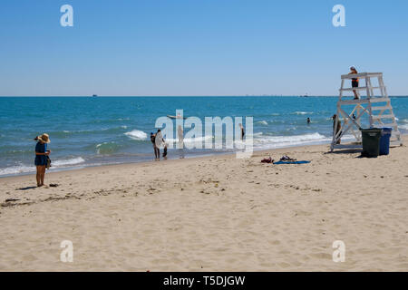 People enjoying a lovely sunny day at Oak Street Beach in Chicago Stock Photo