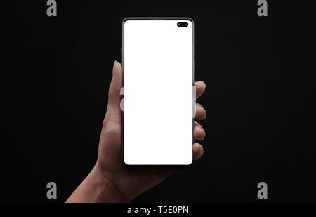 Phone mockup. Low light scene of modern smart phone with round edges and under display camera in woman hand. Isoalted, blank, white screen for app des Stock Photo