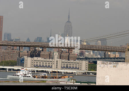 On the East River shore in Brooklyn, New York, with view of the Brooklyn Bridge. In the background, view of  Manhattan, with Empire State Building. Stock Photo