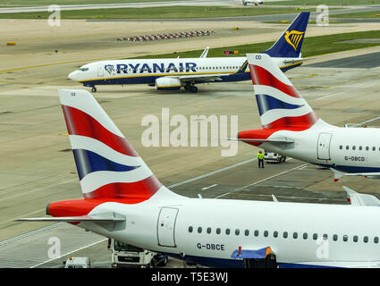 LONDON GATWICK AIRPORT, ENGLAND - APRIL 2019: Tail fins of two British Airways jets at Gatwick Airport with a plane of competitor airline Ryanair Stock Photo