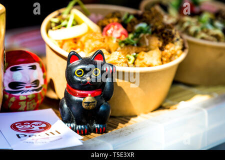 Cute Japanese lucky cat figurine at Pochi street food stall in Victoria Park Market, London, UK Stock Photo