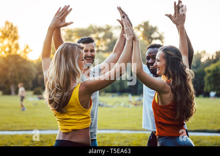 Friends having fun in the park enjoying themselves Stock Photo