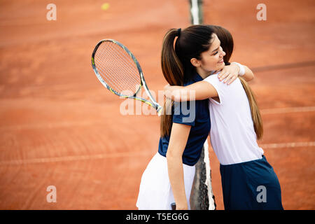 Women tennis player handshaking after playing a tennis match. Fairplay, sport concept. Stock Photo