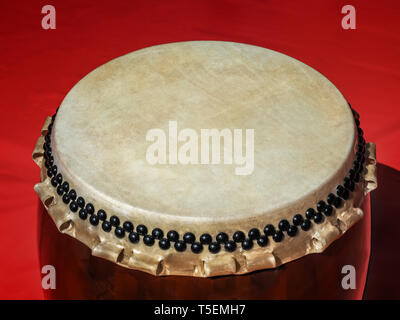 A big Taiko drum o-daiko on isolated red background. Musical percussion instrument of Asia Stock Photo