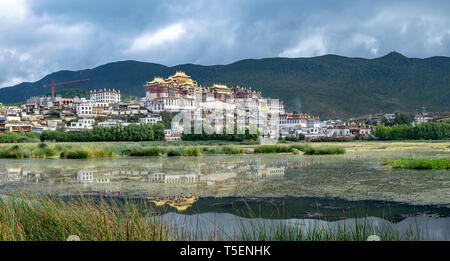 Songzanlin Tibetan Buddhist Monastery reflected in sacred lake, Shangri-La, Yunnan Province, China Stock Photo