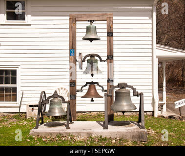 Marcellus , New York, USA. April 17, 2019. Antique bells on display behind  the Tefft-Steadman House in Marcellus, NY Stock Photo