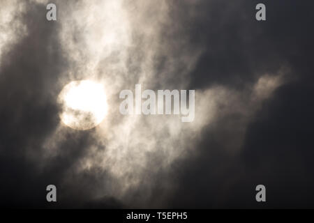 the sun hide behind grey cloud on evening Stock Photo