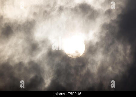 the sun hide behind grey cloud on evening Stock Photo