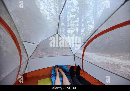 Couple in love lying in a tent with view on the mountains Stock Photo