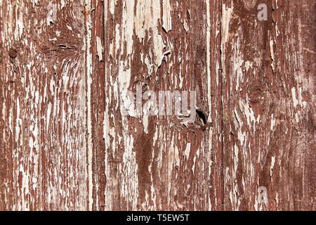 Old wooden peeling board. Old brown painted planks on a house wall. Old color. Weather effects on wood coating. Stock Photo
