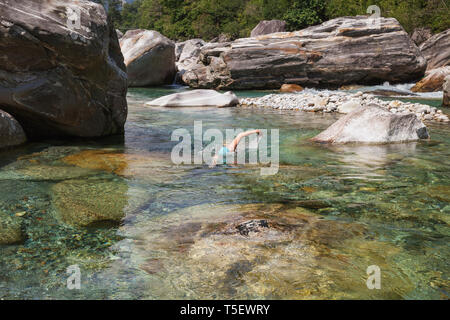 Switzerland, Ticino, Verzasca Valley, woman swimming in refreshing Verszasca river Stock Photo