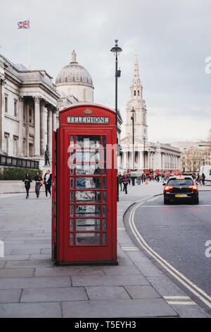 London, UK - April 13, 2019: Red phone box on Pall Mall East, National Gallery on the background. Red phone boxes can be found in current or former Br Stock Photo