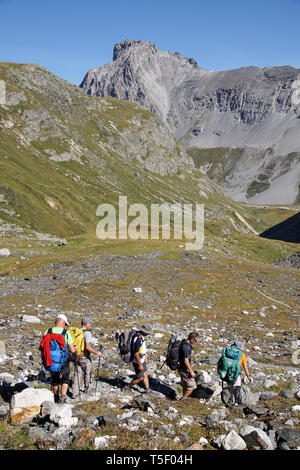 Les Allues (south-eastern France): group of hikers walking through the fallen rocks of the Gebroulaz glacier, facing the “Aiguille du Fruit” peak, in  Stock Photo
