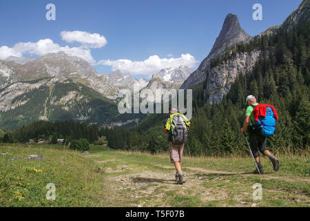 Pralognan-la-Vanoise (south-eastern France): two hikers walking down the Chaviere Valley, facing the 'Grande Casse” mountain, in the Vanoise National  Stock Photo