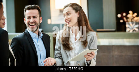 Business people standing and discussing in the hotel lobby Stock Photo