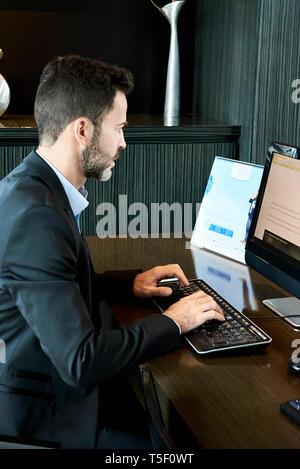 Businessman working on computer in hotel Stock Photo