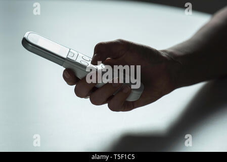 Hand holding AC remote control Stock Photo