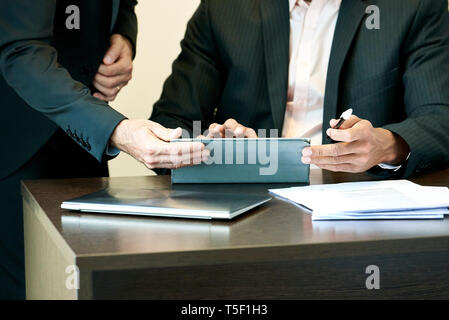 Businessmen using a digital tablet in office Stock Photo