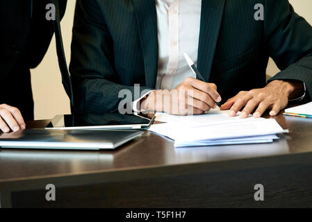 Businessman signing a document in office Stock Photo