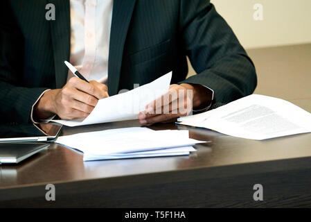 Businessman checking a document on his desk Stock Photo