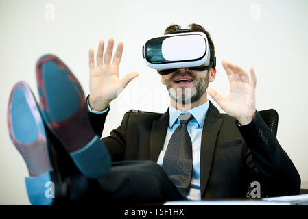 Businessman using virtual reality headset in office Stock Photo