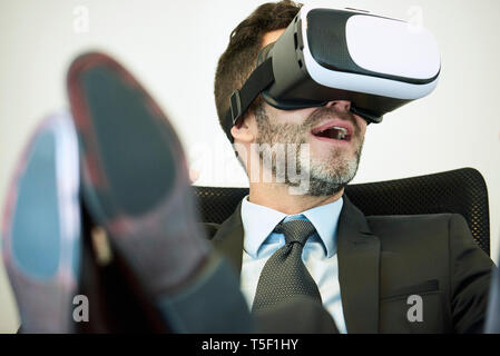 Businessman using virtual reality headset in office Stock Photo