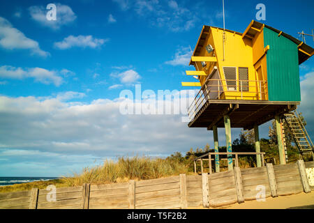 Brightly coloured lifeguard observation tower on sandy beach of Tasman Sea shoreline in Australia. Stock Photo