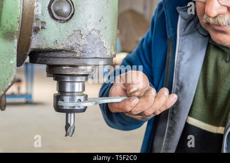 Hands of an old worker using milling machine in factory workshop Stock Photo