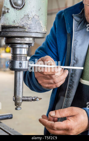 Hands of an old worker using milling machine in factory workshop Stock Photo