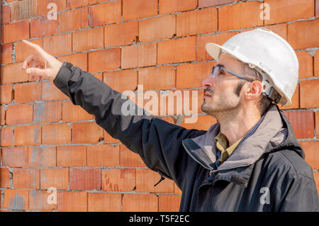 Portrait of a young civil engineer wearing hardhat on construction site Stock Photo