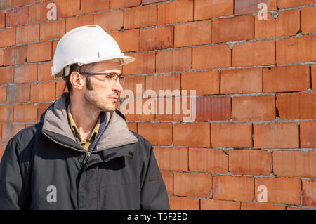 Portrait of a young civil engineer wearing hardhat on construction site Stock Photo
