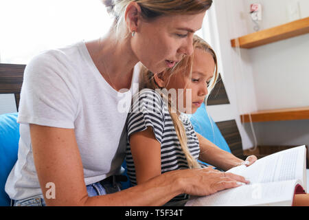 Mother helping daughter with difficult task Stock Photo