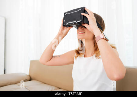 Smiling woman looking through goggles Stock Photo