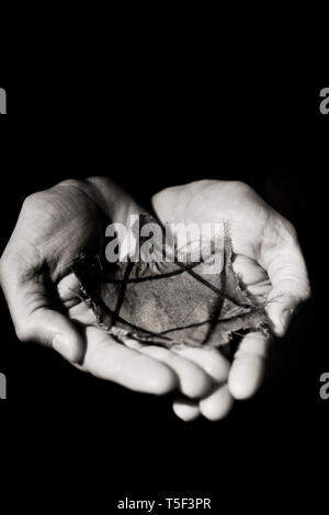 closeup of a ragged Jewish badge in the hands of a man Stock Photo