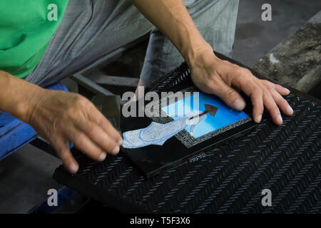 man makes a mosaic of hands with the image of a Vietnamese girl. Stock Photo
