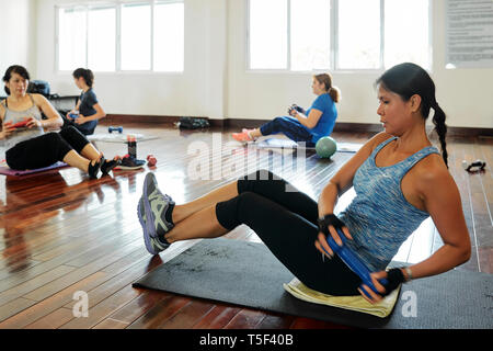 Young women doing side twists Stock Photo