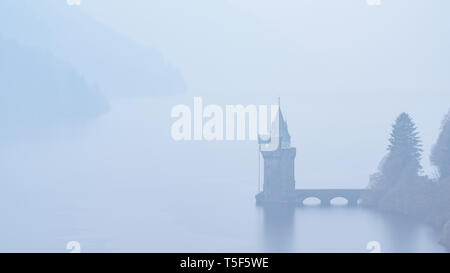 View of Lake Vyrnwy and straining tower in mist. Stock Photo