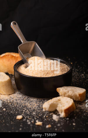 Food ingredients homemade organic bread crumbs in black ceramic bowl on black slate board Stock Photo