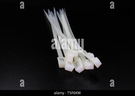 White nylon cable tie isolated on a black background High resolution image gallery. Stock Photo