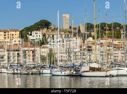 CANNES, FRANCE - APRIL 2019: Sailing boats in the harbour in Cannes. In the background is the castle tower'. Stock Photo